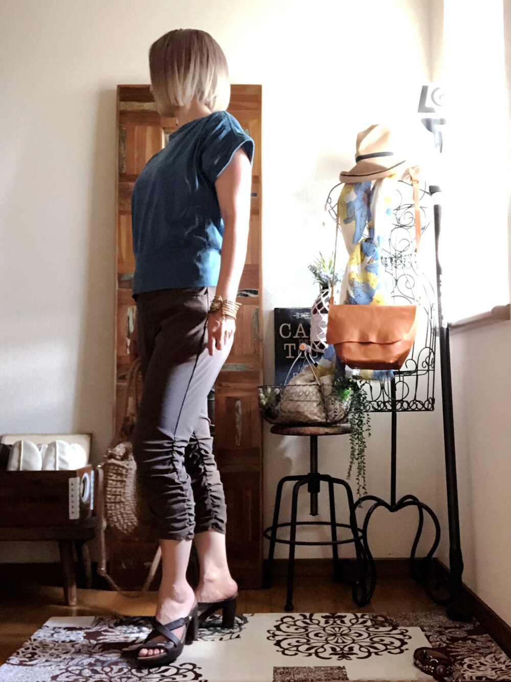 グリーン系のTシャツ/カットソー、ブラウン系のその他パンツ、ベージュ系のかごバッグを着用したレディースの夏コーディネートの3枚目の写真