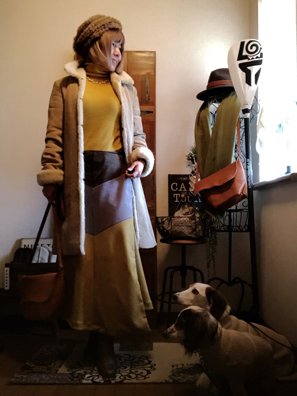 イエロー系のショルダーバッグ、ベージュ系のムートンコート、イエロー系のニット/セーターを着用したレディースの冬コーディネートの2枚目の写真