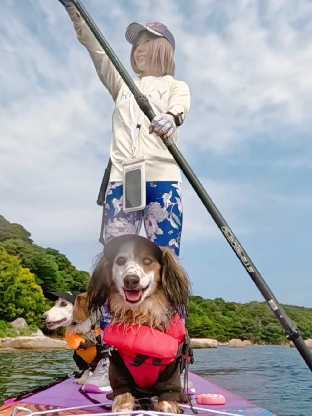 ブルー系のキャップ、ピンク系のウィッグ、ホワイト系のラッシュガードを着用したレディースの夏コーディネートの2枚目の写真