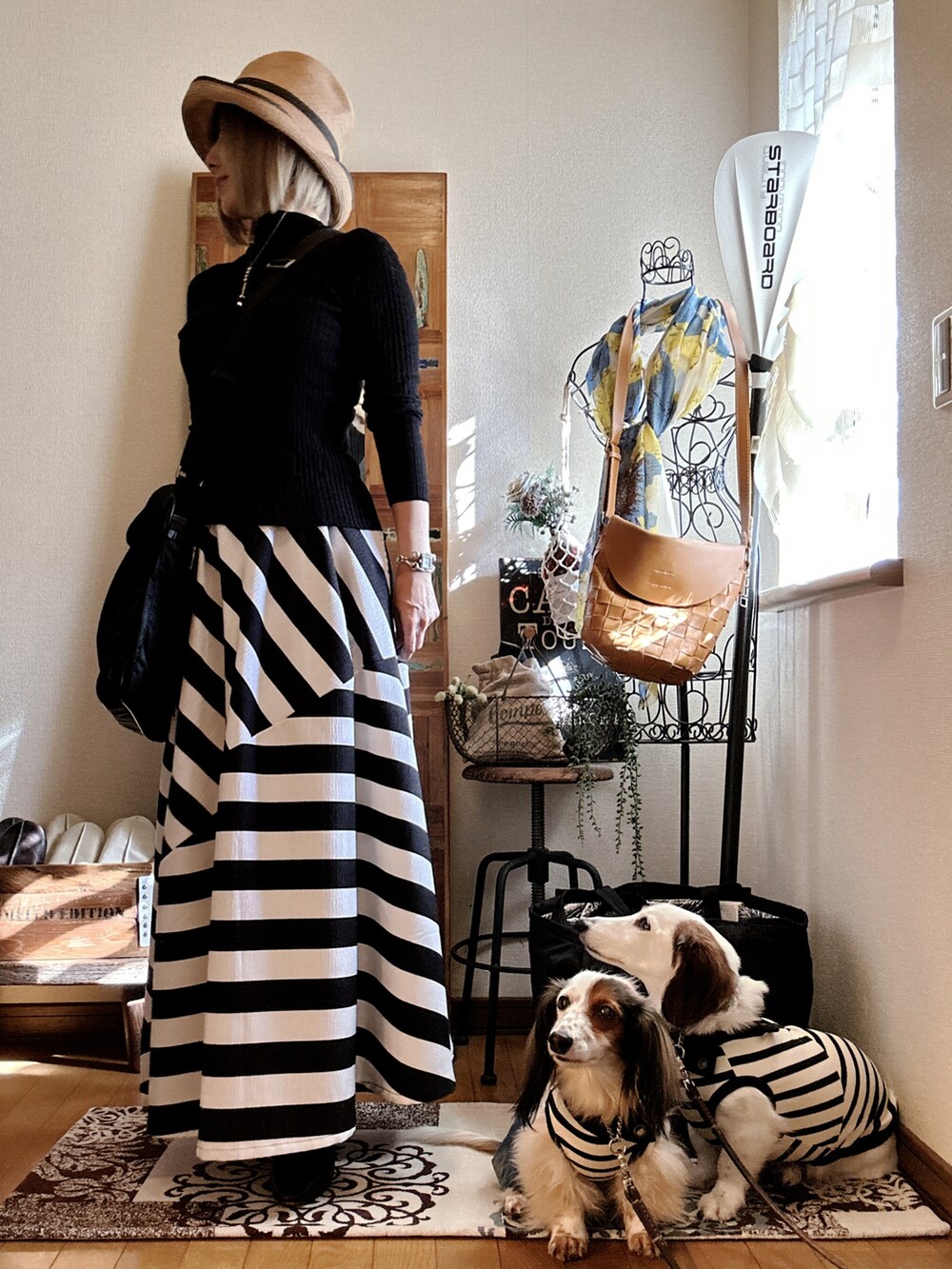 ブラック系のニット/セーター、ブラック系のショルダーバッグ、ブラック系のスカートを着用したレディースの秋コーディネートの2枚目の写真