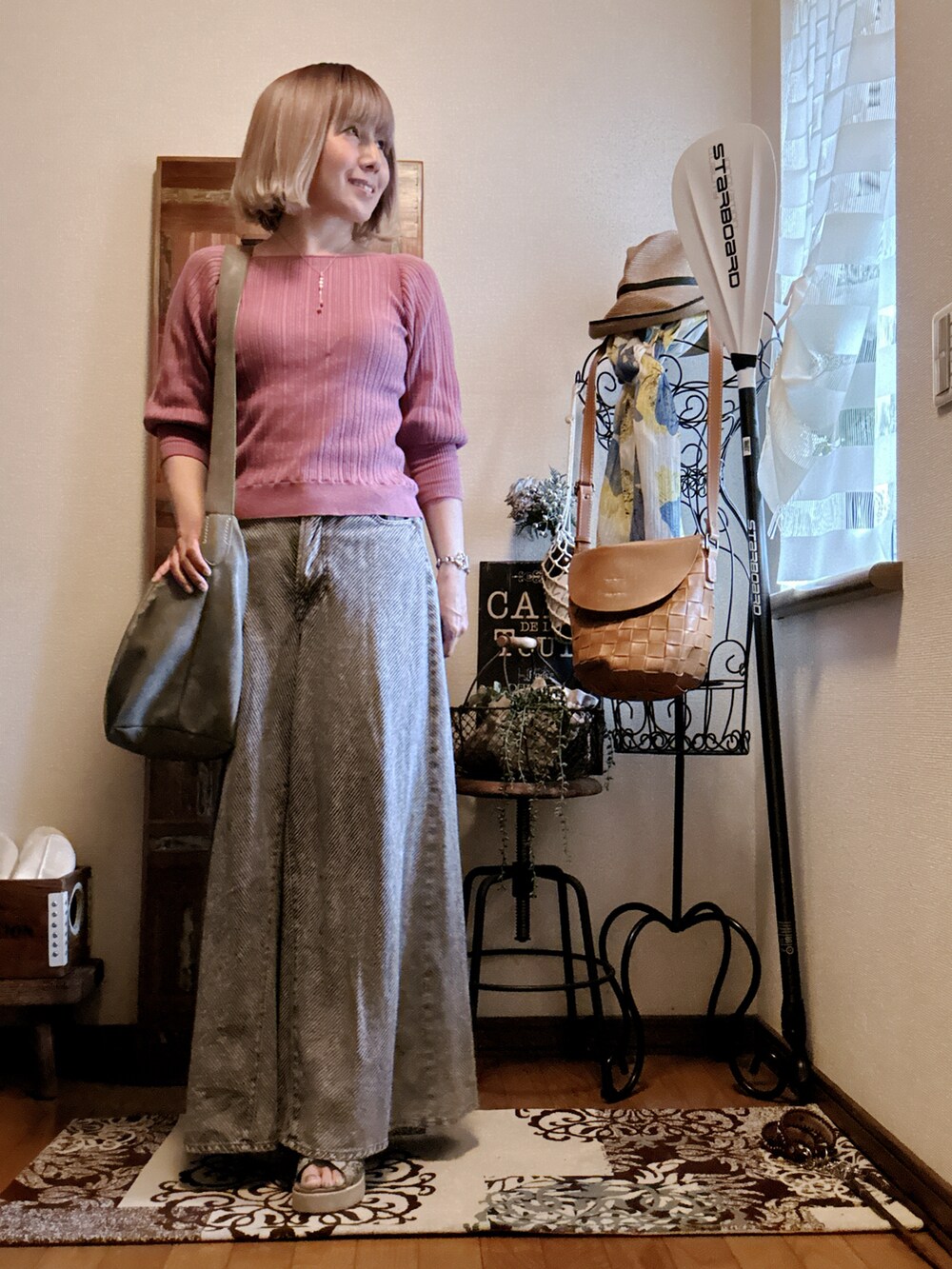 ピンク系のニット/セーター、グレー系のショルダーバッグ、ブラック系のデニムパンツを着用したレディースの春コーディネートの2枚目の写真