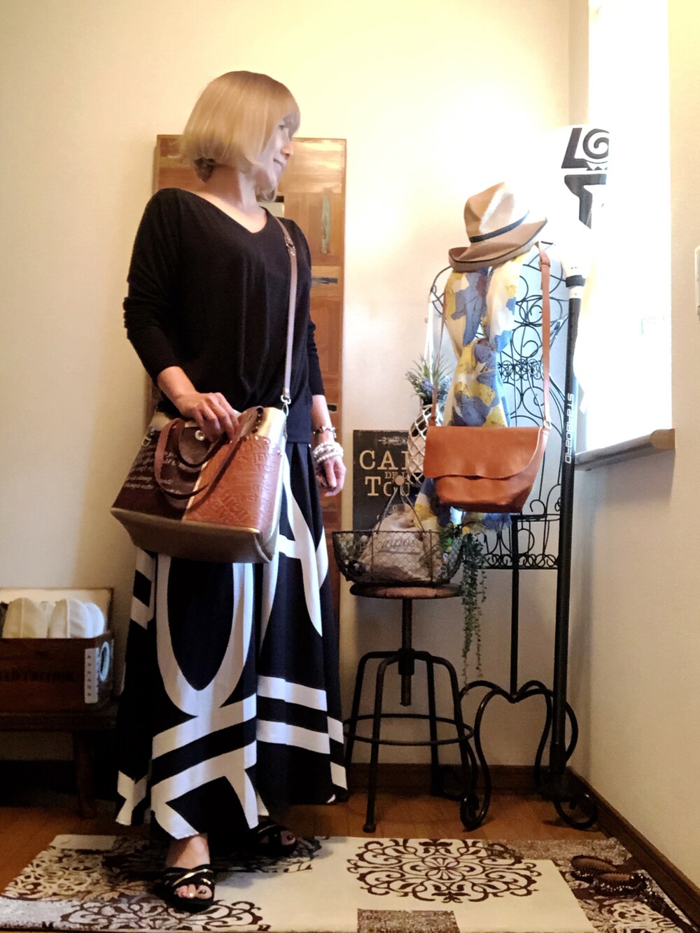 ブラック系のスカート、ブラウン系のショルダーバッグ、ブラック系のTシャツ/カットソーを着用したレディースの夏コーディネートの2枚目の写真