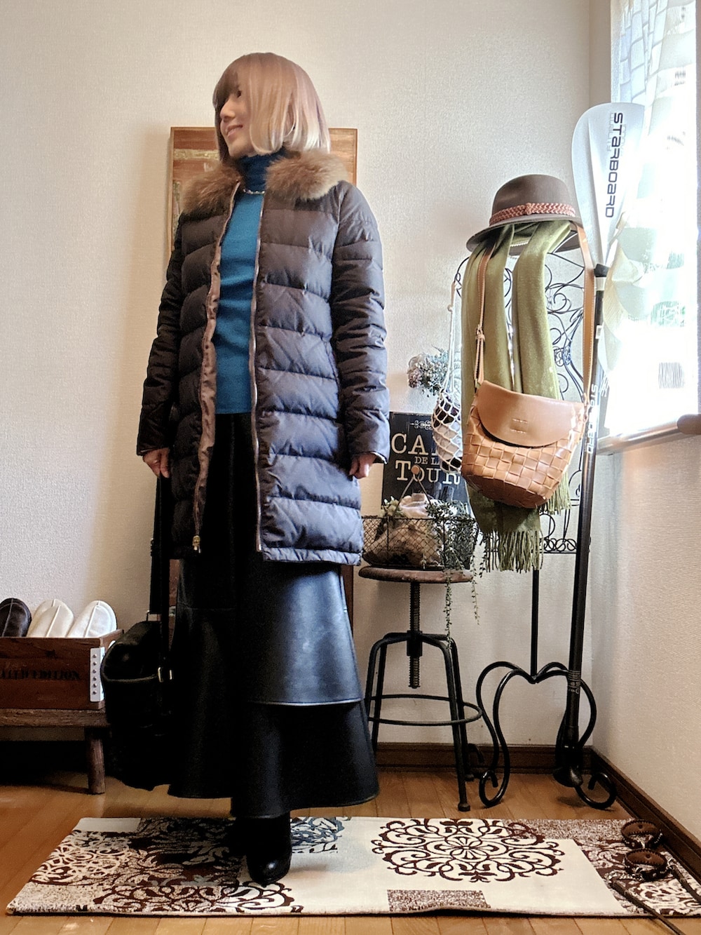 ブルー系のニット/セーター、ベージュ系のダウンジャケット/コート、ブラック系のショルダーバッグを着用したレディースの冬コーディネートの2枚目の写真