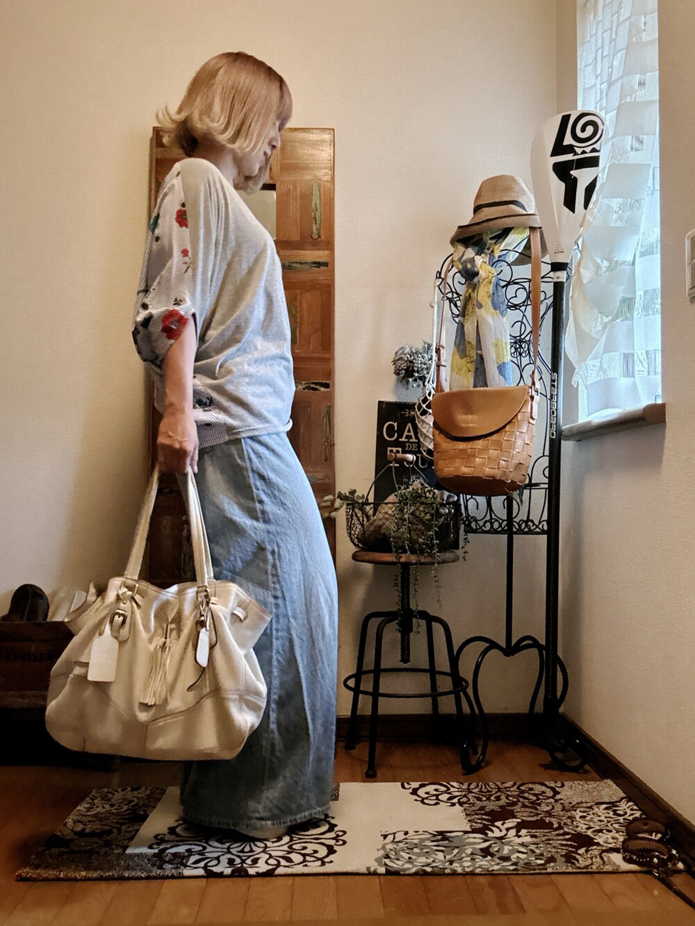 ホワイト系のバッグ、ブルー系のデニムパンツ、グレー系のTシャツ/カットソーを着用したレディースの夏コーディネートの3枚目の写真