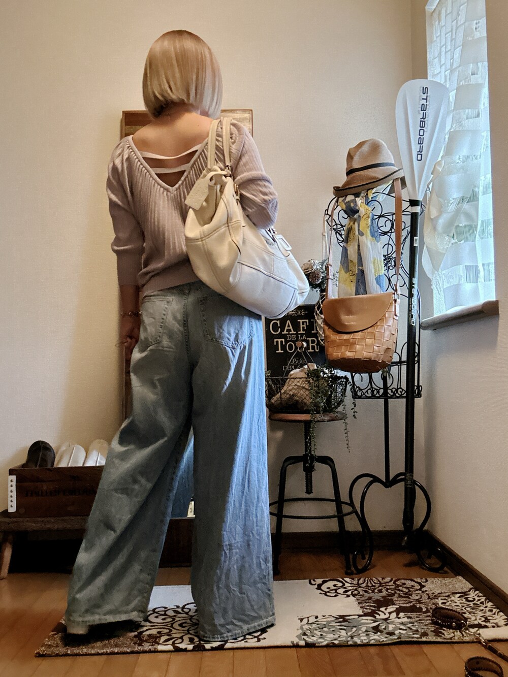 ホワイト系のバッグ、パープル系のニット/セーター、ブルー系のデニムパンツを着用したレディースの秋コーディネートの2枚目の写真