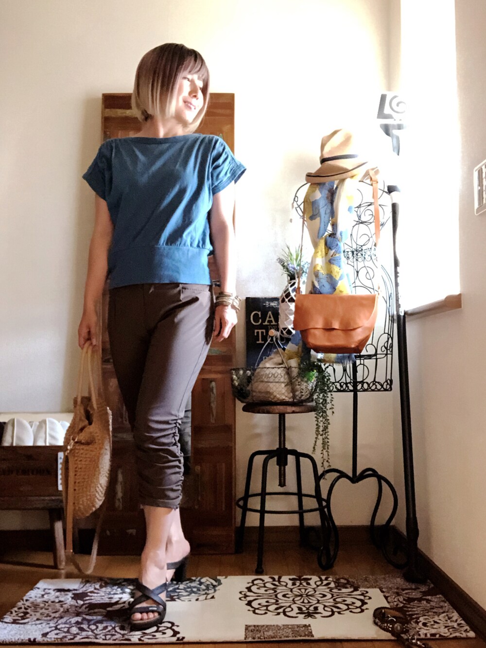 グリーン系のTシャツ/カットソー、ブラウン系のその他パンツ、ベージュ系のかごバッグを着用したレディースの夏コーディネートの2枚目の写真