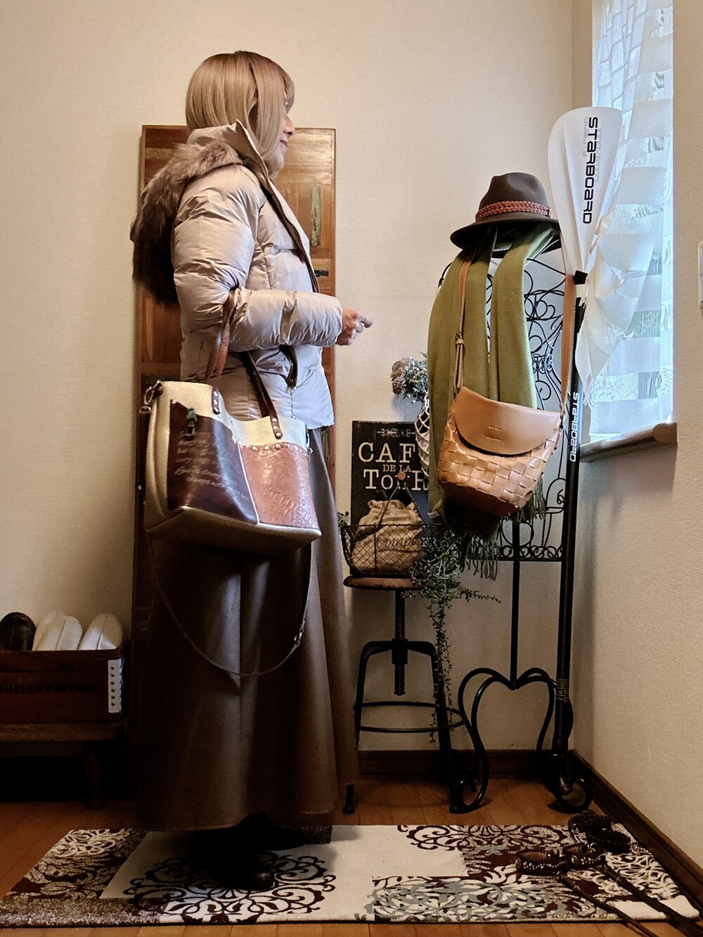 ベージュ系のニット/セーター、ベージュ系のダウンジャケット/コート、ブラウン系のスカートを着用したレディースの冬コーディネートの2枚目の写真