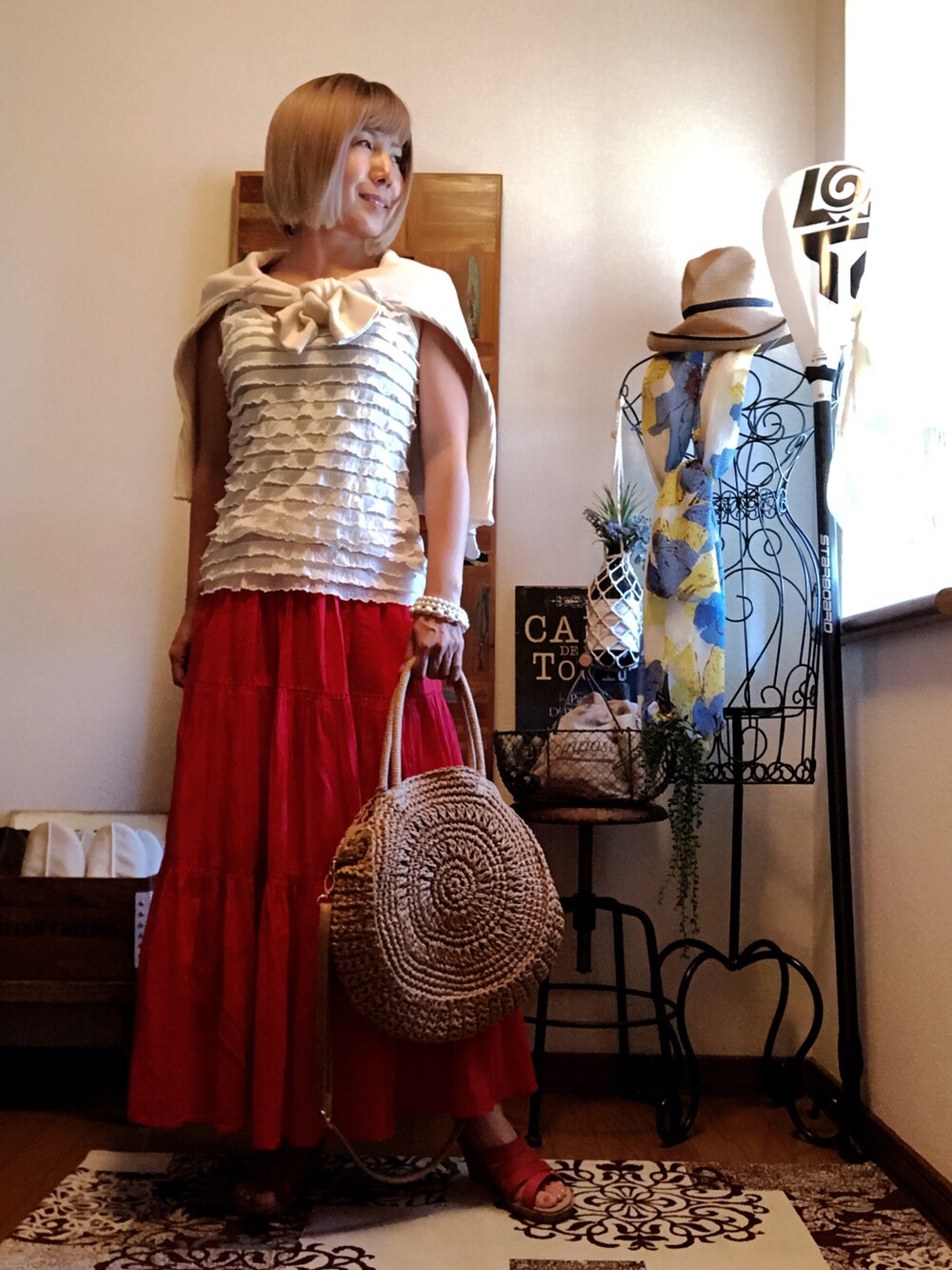 ホワイト系のニット/セーター、ベージュ系のかごバッグ、レッド系のスカートを着用したレディースの秋コーディネートの2枚目の写真