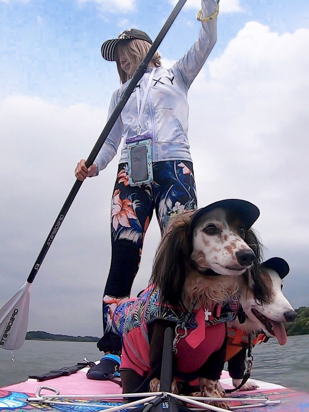 ブラック系のキャップ、ホワイト系のラッシュガード、ブラック系のレギンス/スパッツを着用したレディースの夏コーディネートの3枚目の写真