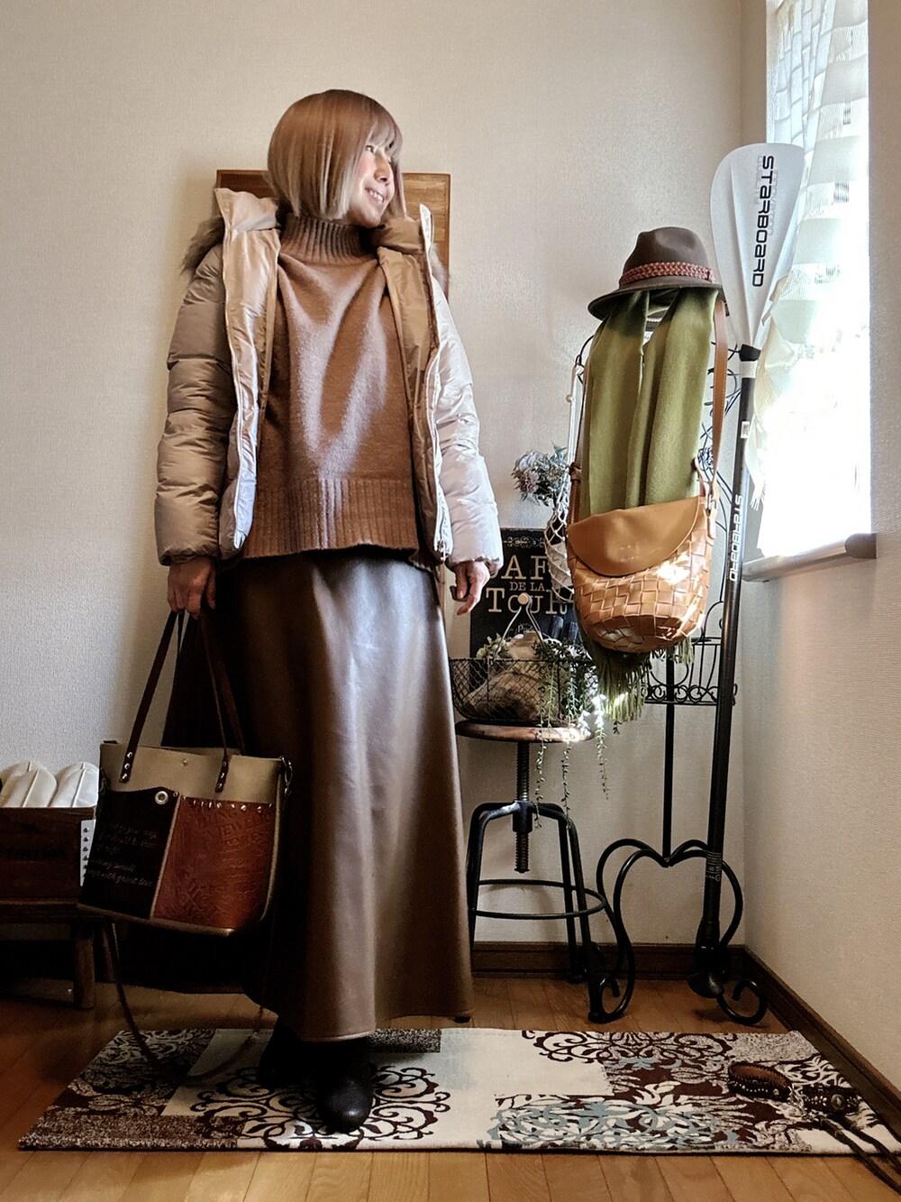 ベージュ系のダウンジャケット/コート、ベージュ系のニット/セーター、ブラウン系のブーツを着用したレディースの冬コーディネートの2枚目の写真