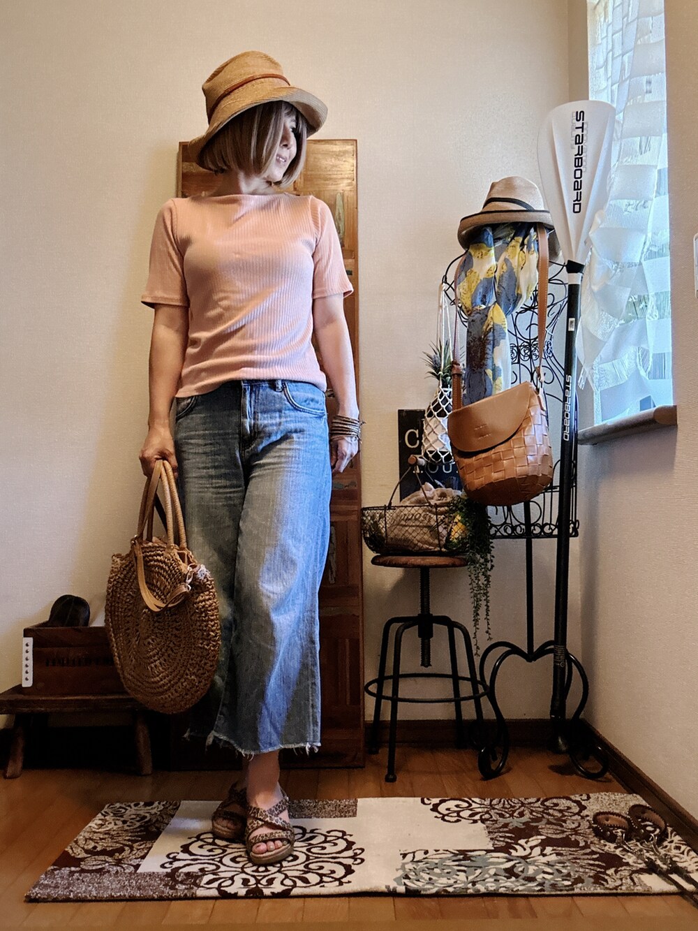 ピンク系のTシャツ/カットソー、ベージュ系のかごバッグ、ゴールド系のサンダルを着用したレディースの秋コーディネートの2枚目の写真