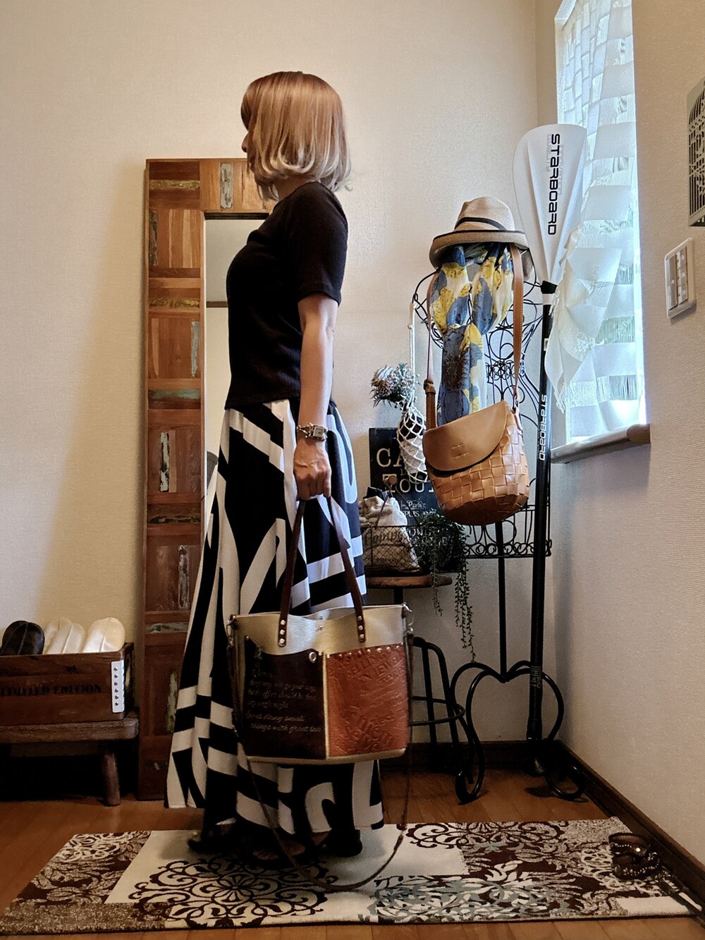 ブラック系のスカート、ブラウン系のショルダーバッグ、ブラック系のTシャツ/カットソーを着用したレディースの秋コーディネートの2枚目の写真