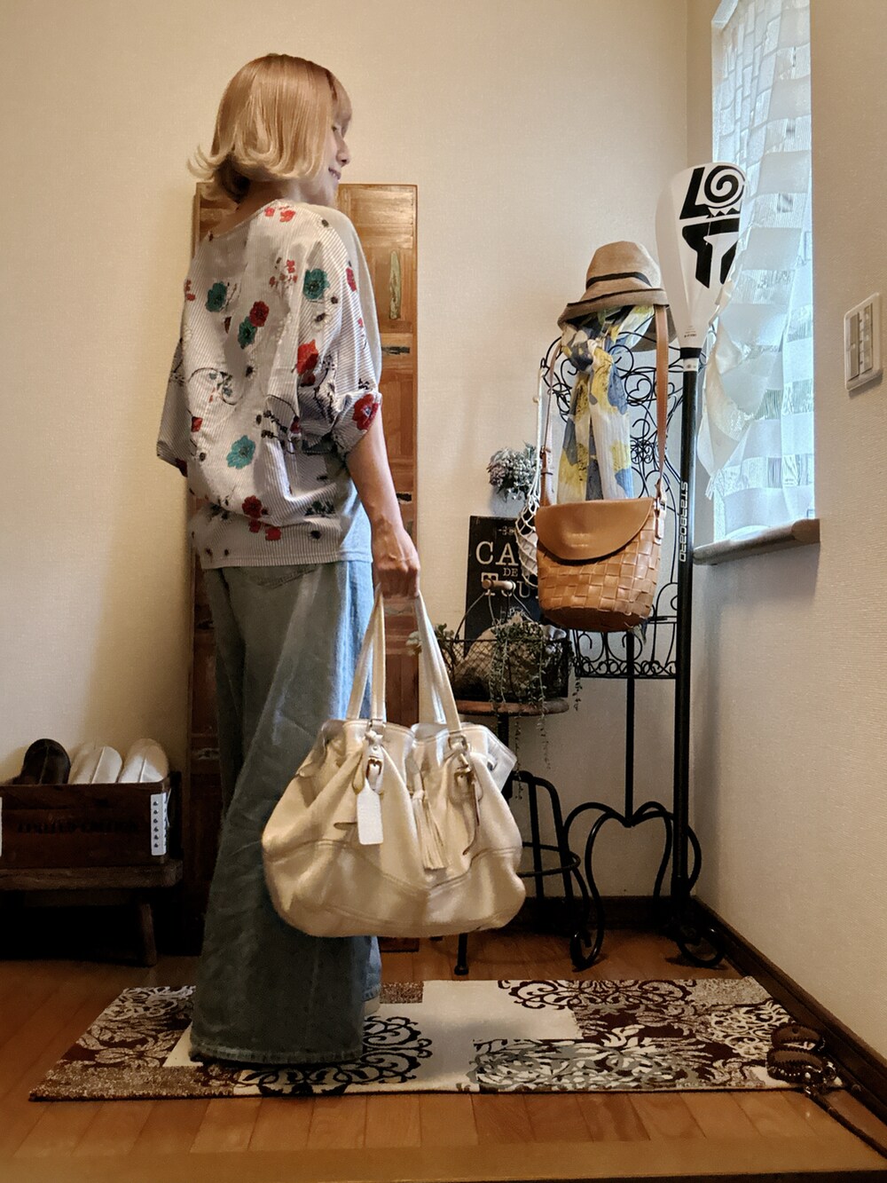 ホワイト系のバッグ、ブルー系のデニムパンツ、グレー系のTシャツ/カットソーを着用したレディースの夏コーディネートの2枚目の写真