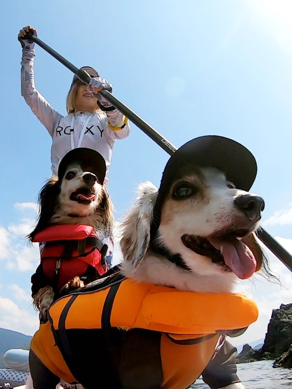 ブルー系のタンクトップ、ブルー系のキャップ、ホワイト系のラッシュガードを着用したレディースの秋コーディネートの2枚目の写真