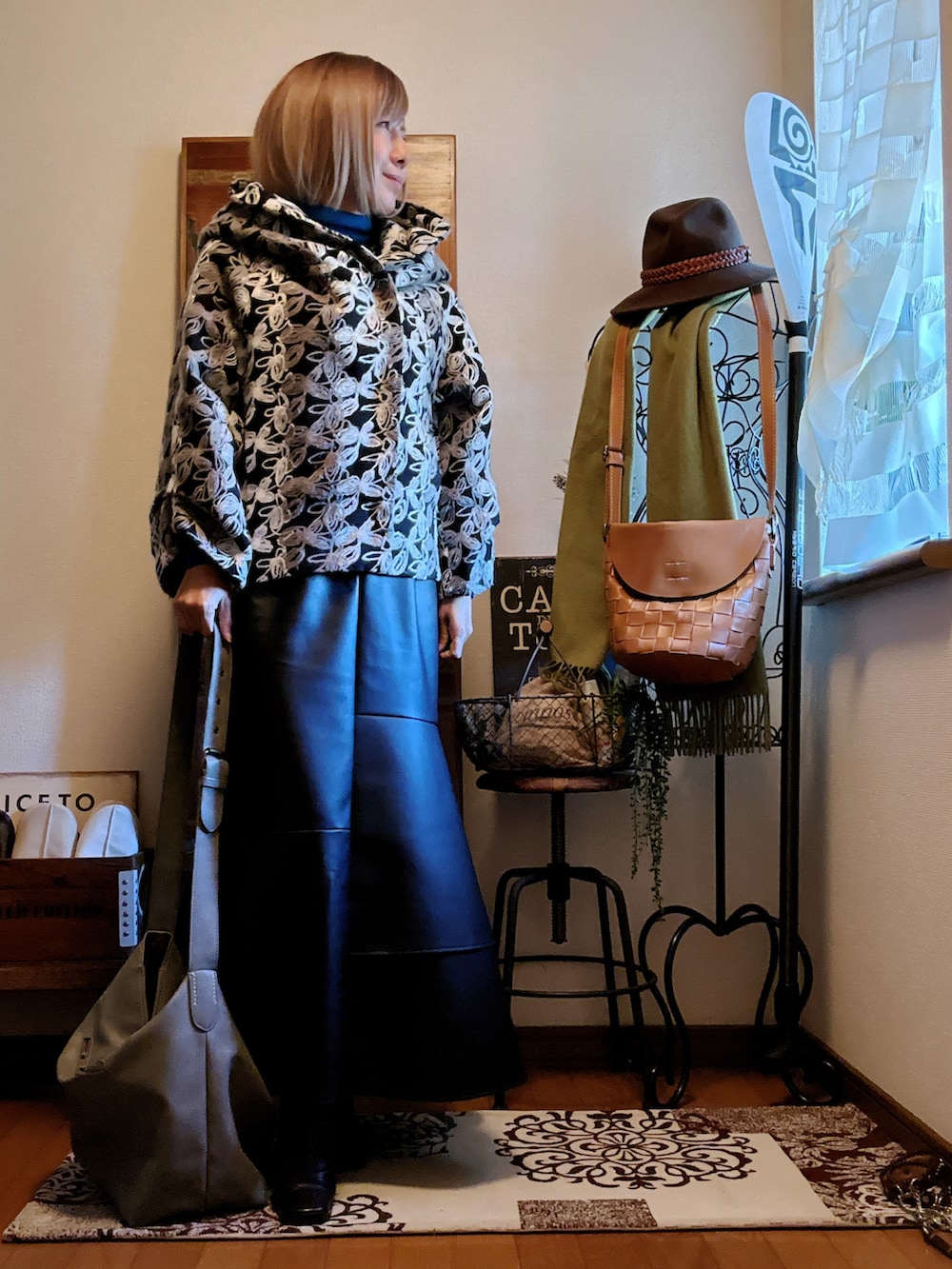 ブラック系のその他アウター、グレー系のショルダーバッグ、ブルー系のニット/セーターを着用したレディースの冬コーディネートの2枚目の写真