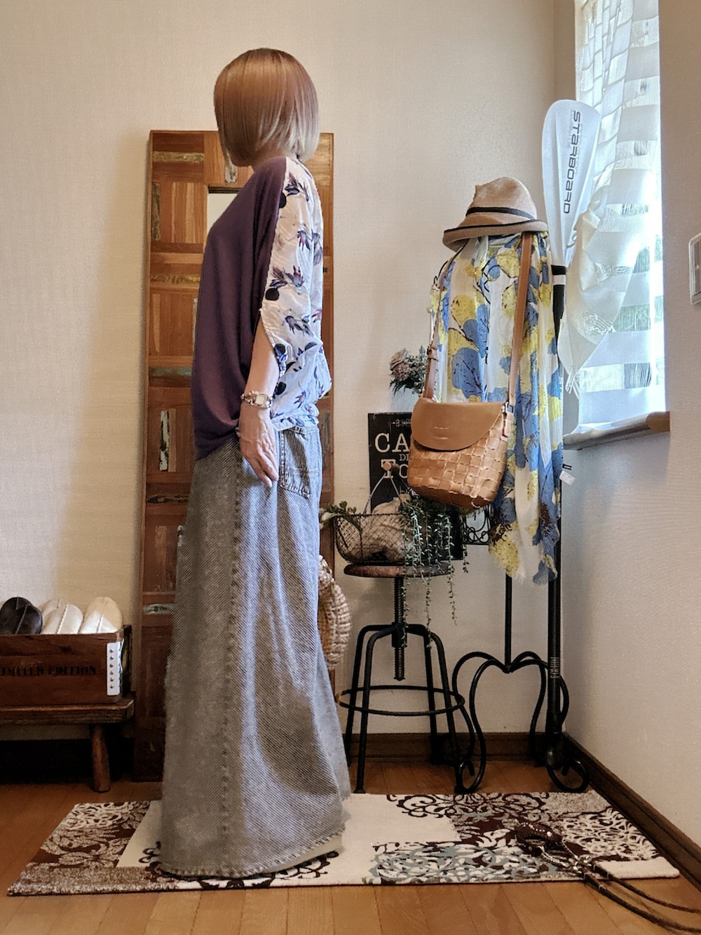 パープル系のTシャツ/カットソー、ブラック系のデニムパンツ、ベージュ系のかごバッグを着用したレディースの夏コーディネートの3枚目の写真