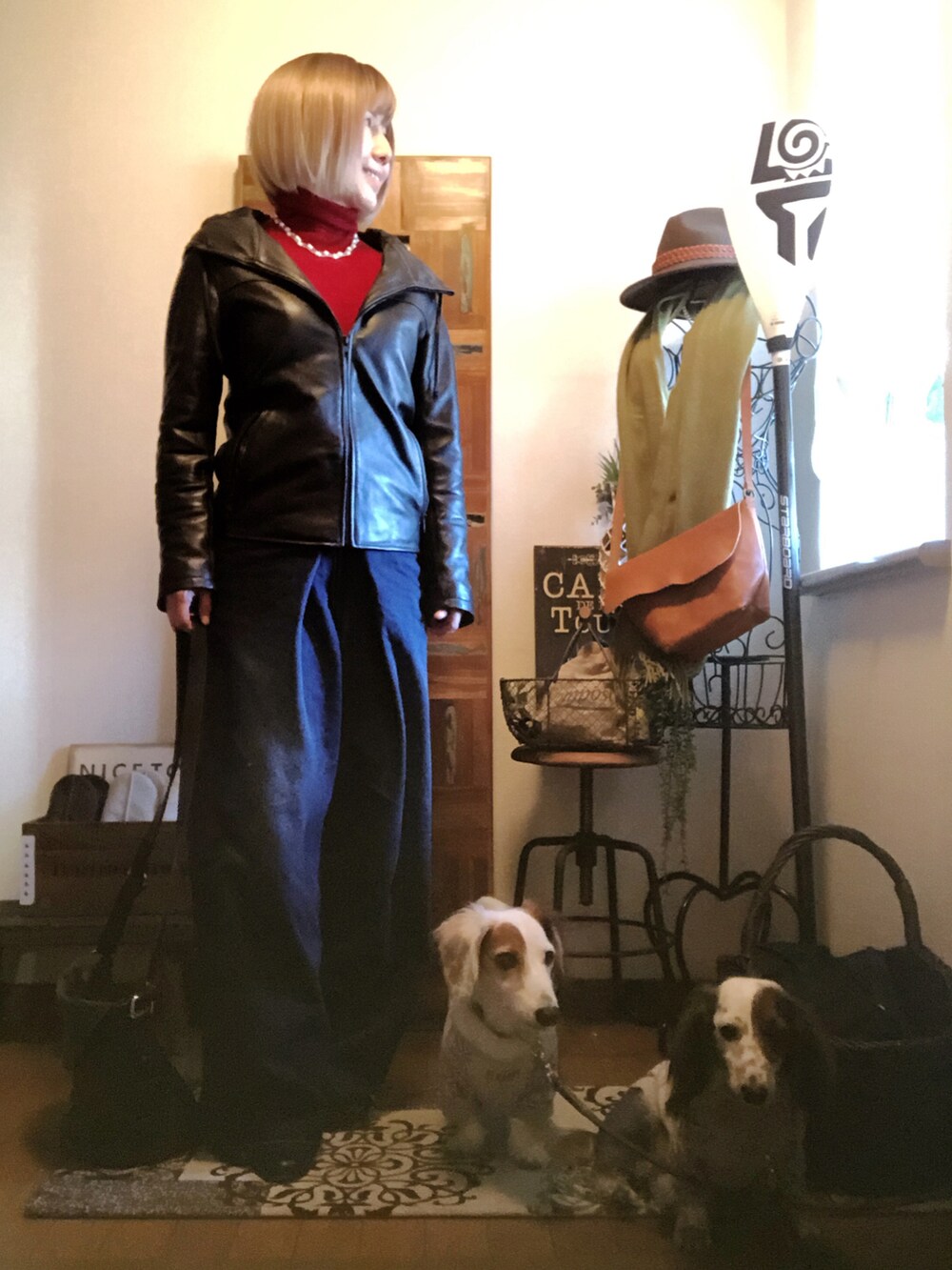 レッド系のニット/セーター、ブルー系のデニムパンツ、ブラック系のライダースジャケットを着用したレディースの秋コーディネートの2枚目の写真