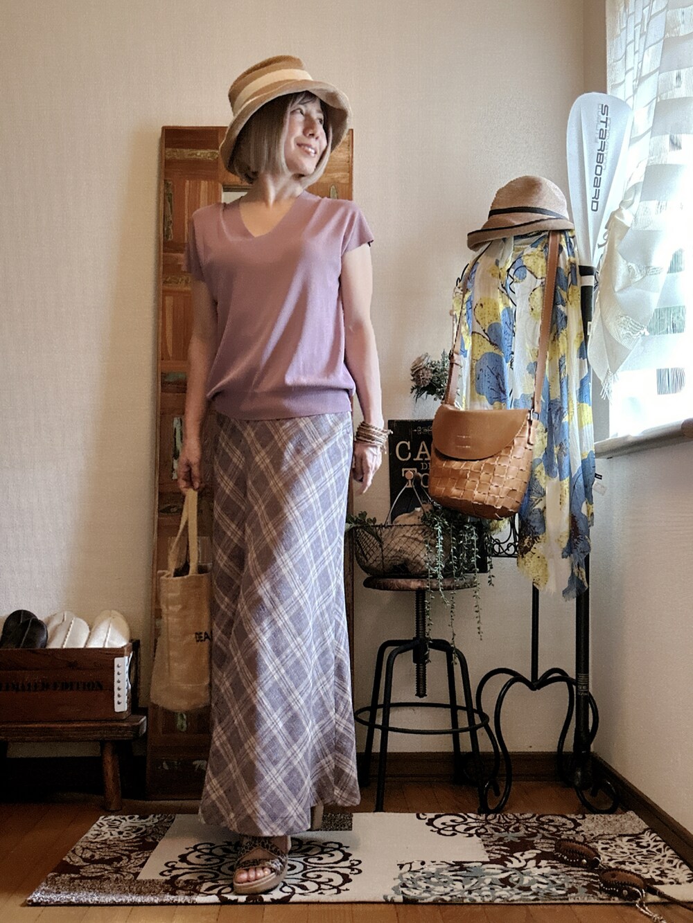 パープル系のニット/セーター、ベージュ系のスカート、ベージュ系のトートバッグを着用したレディースの夏コーディネートの3枚目の写真