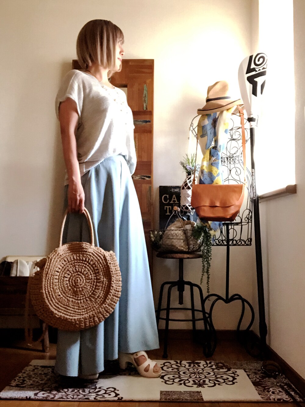 シルバー系のTシャツ/カットソー、ベージュ系のかごバッグ、グリーン系のスカートを着用したレディースの夏コーディネートの2枚目の写真