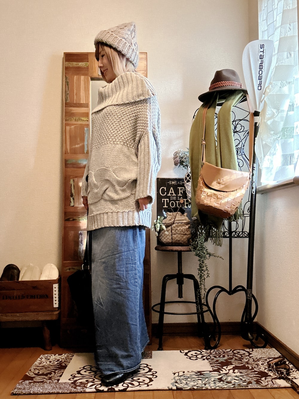 グレー系のニット/セーター、ブラック系のブーツ、ブルー系のデニムスカートを着用したレディースの冬コーディネートの2枚目の写真