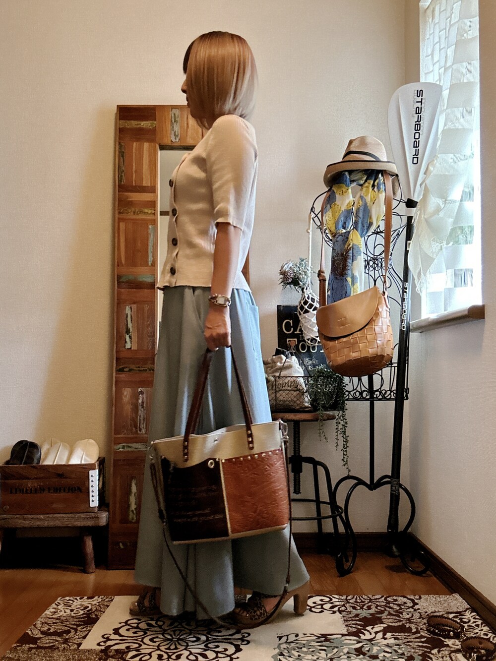 ホワイト系のニット/セーター、ブラウン系のショルダーバッグ、グリーン系のスカートを着用したレディースの秋コーディネートの2枚目の写真