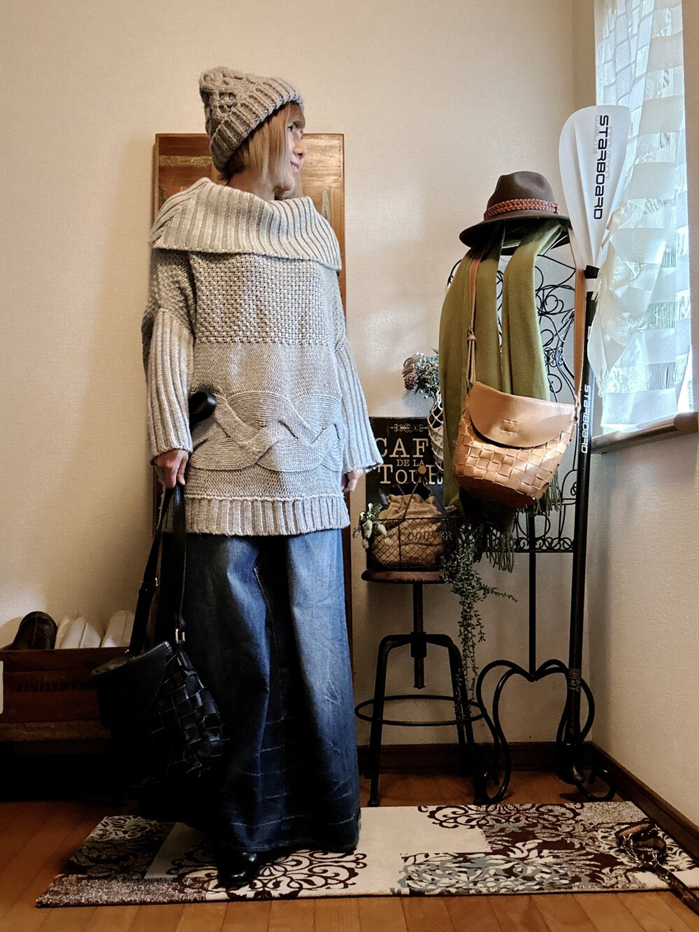 グレー系のニット/セーター、ブラック系のブーツ、ブルー系のデニムスカートを着用したレディースの冬コーディネートの3枚目の写真