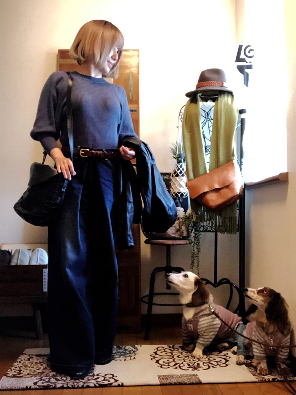 ブルー系のデニムパンツ、ブラック系のライダースジャケット、ブルー系のニット/セーターを着用したレディースの春コーディネートの2枚目の写真