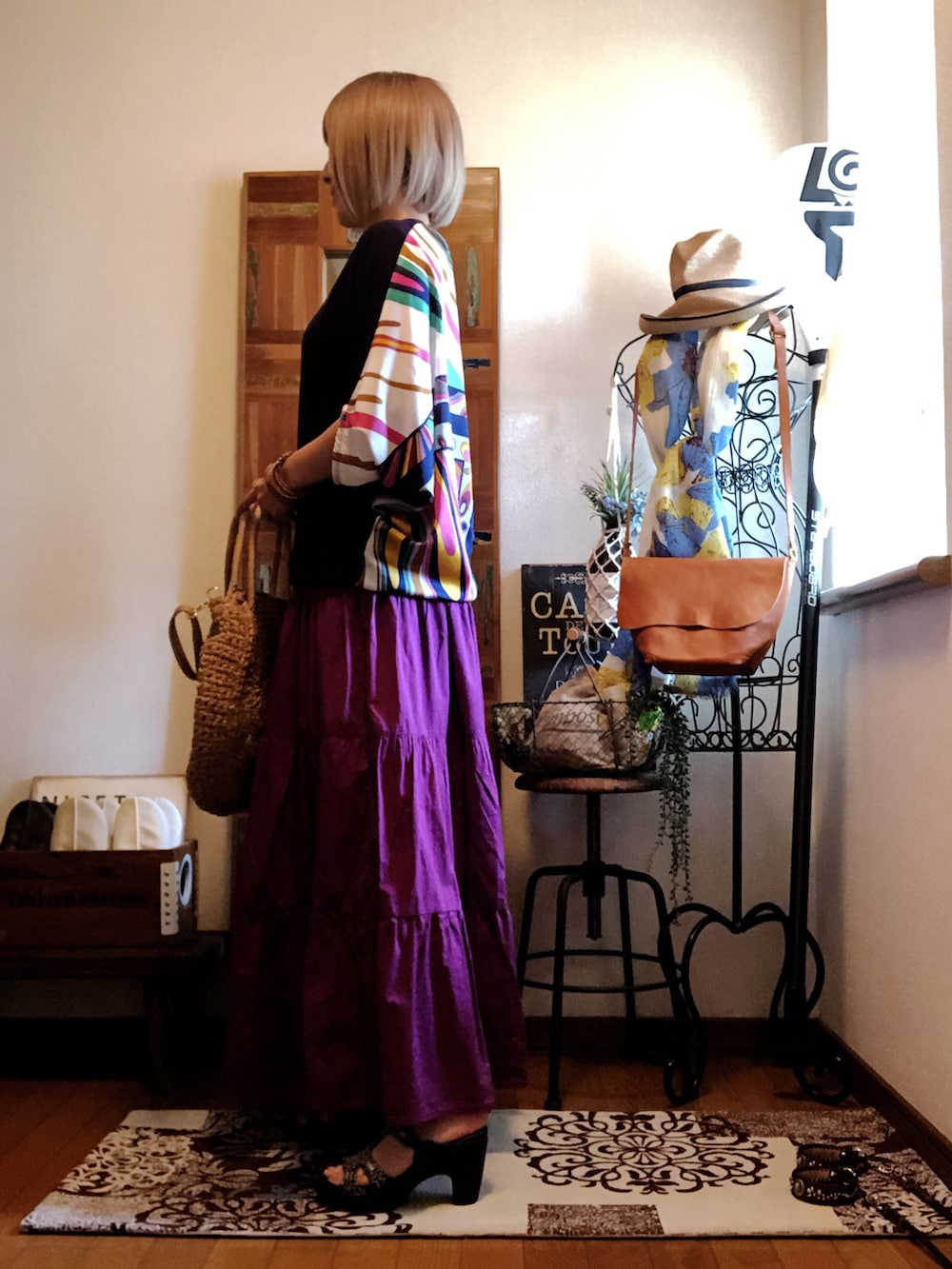 ベージュ系のかごバッグ、ピンク系のスカート、ブラック系のサンダルを着用したレディースの夏コーディネートの2枚目の写真