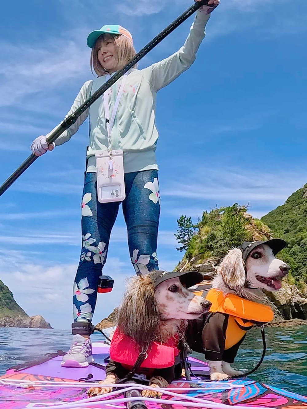 ブルー系のラッシュガード、ブルー系のレギンス/スパッツ、グリーン系のキャップを着用したレディースの夏コーディネートの2枚目の写真