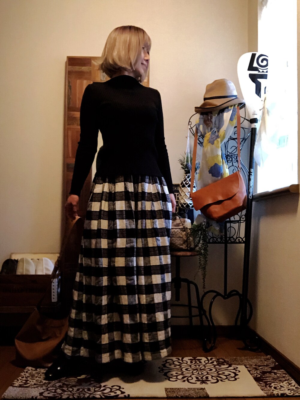 イエロー系のショルダーバッグ、ブラック系のニット/セーター、ブラック系のその他パンツを着用したレディースの春コーディネートの2枚目の写真