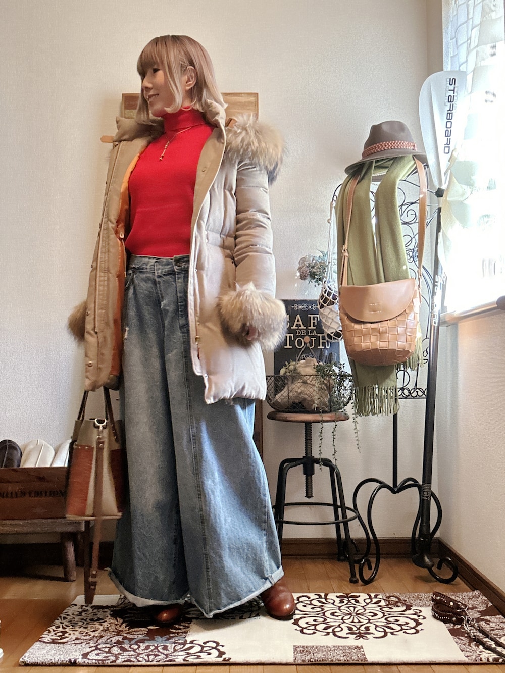 ベージュ系のダウンジャケット/コート、レッド系のニット/セーター、ブラウン系のブーツを着用したレディースの冬コーディネートの2枚目の写真