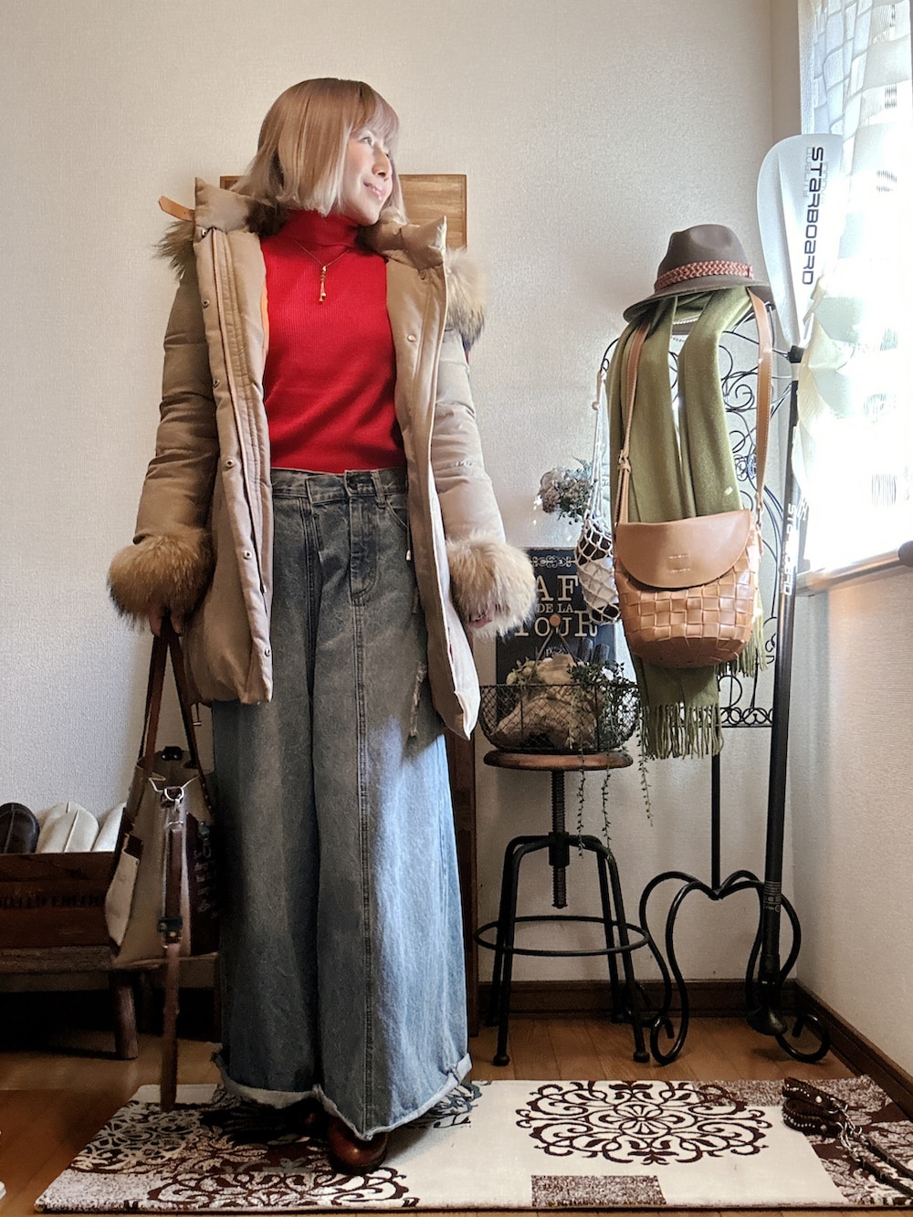 ベージュ系のダウンジャケット/コート、レッド系のニット/セーター、ブラウン系のブーツを着用したレディースの冬コーディネートの3枚目の写真