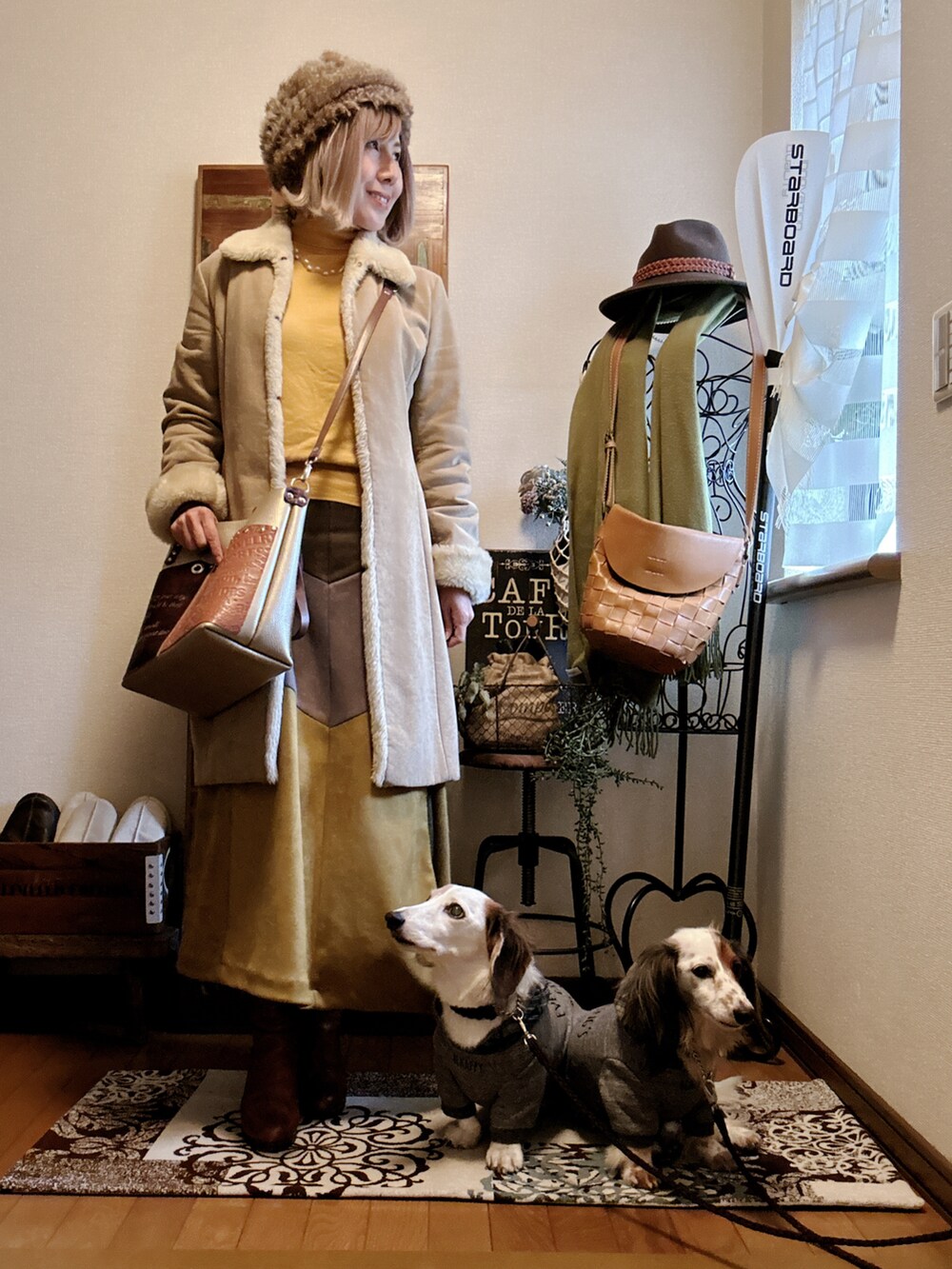 イエロー系のニット/セーター、ブラウン系のブーツ、イエロー系のスカートを着用したレディースの冬コーディネートの2枚目の写真