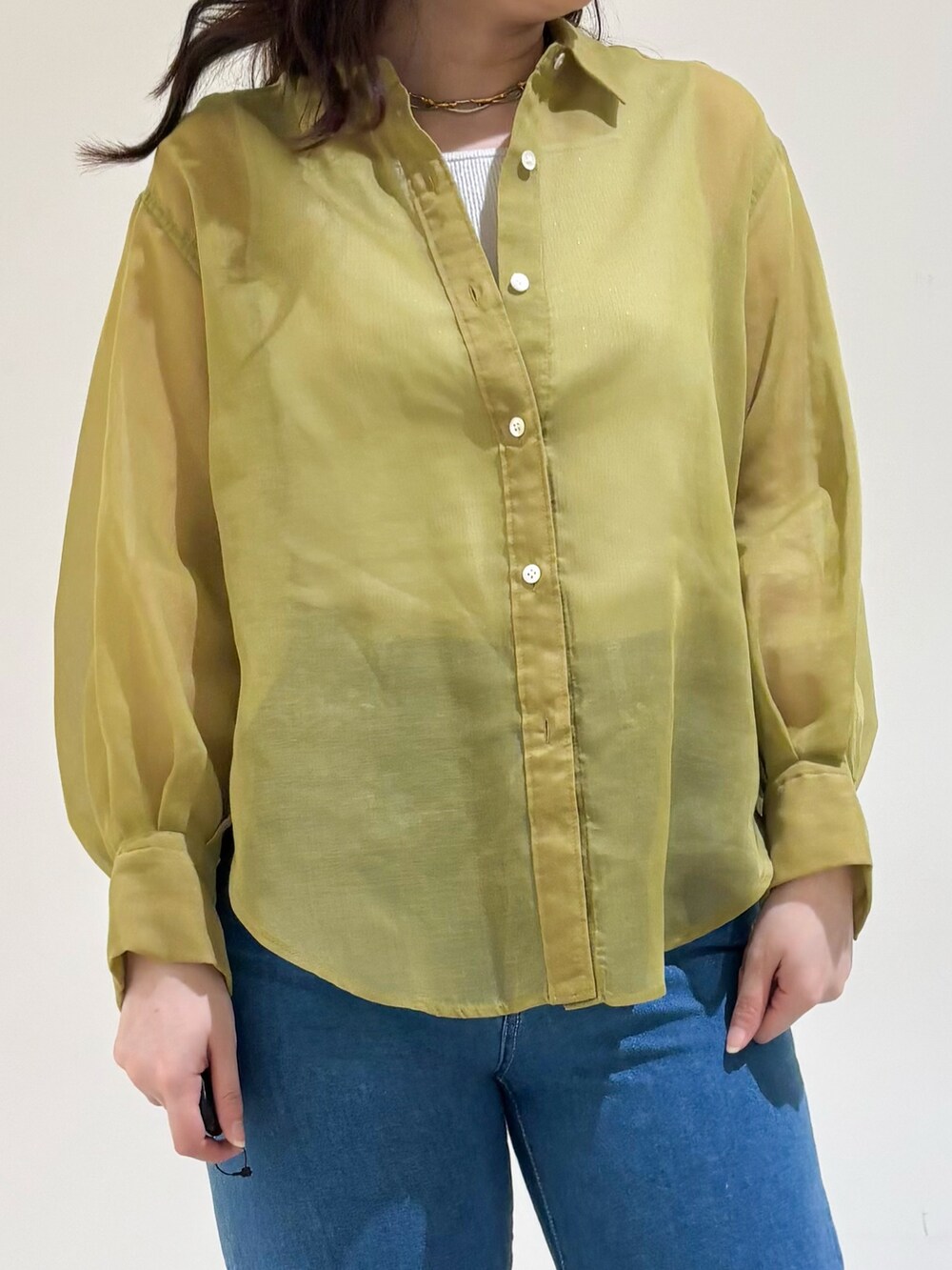 グレー系のタンクトップ、イエロー系のシャツ/ブラウス、ブルー系のデニムパンツを着用したレディースの春コーディネートの4枚目の写真