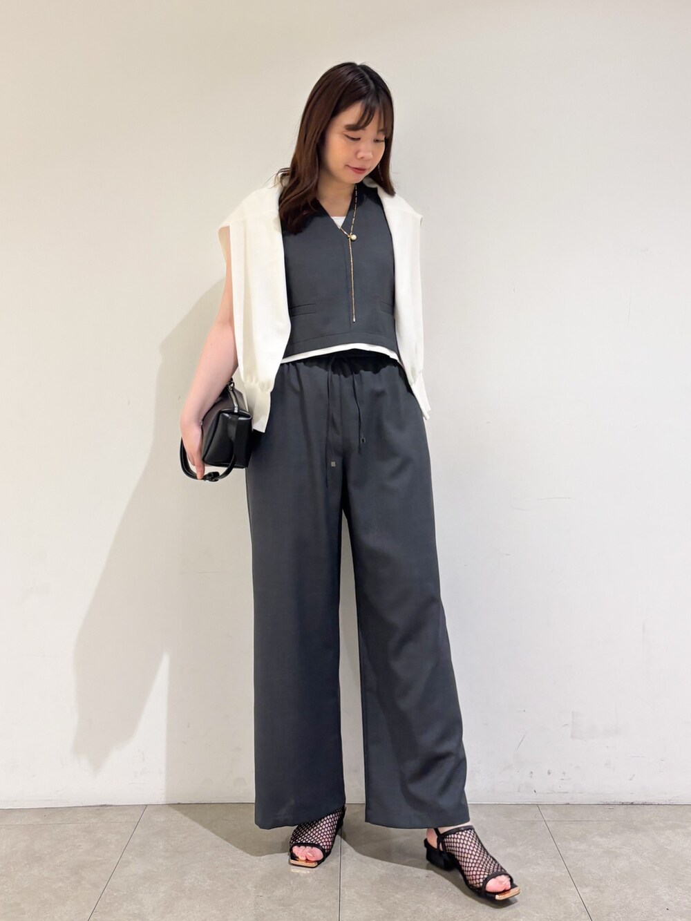 グレー系のその他パンツ、ブラック系のサンダル、グレー系のタンクトップを着用したレディースの夏コーディネートの4枚目の写真
