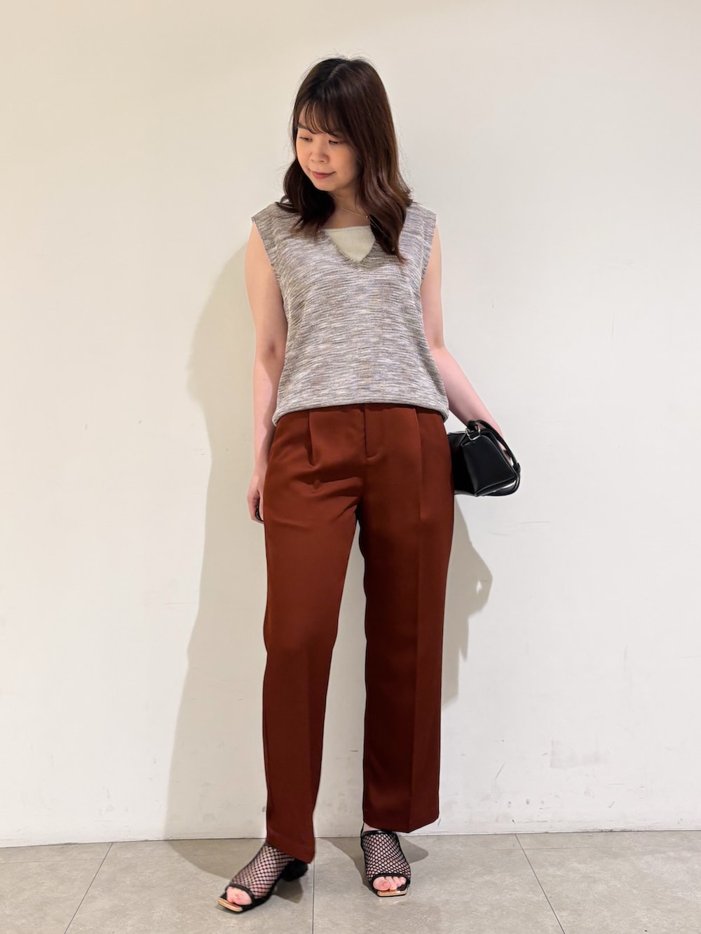 ピンク系のベスト、ブラウン系のその他パンツ、ブラック系のサンダルを着用したレディースの秋コーディネートの4枚目の写真