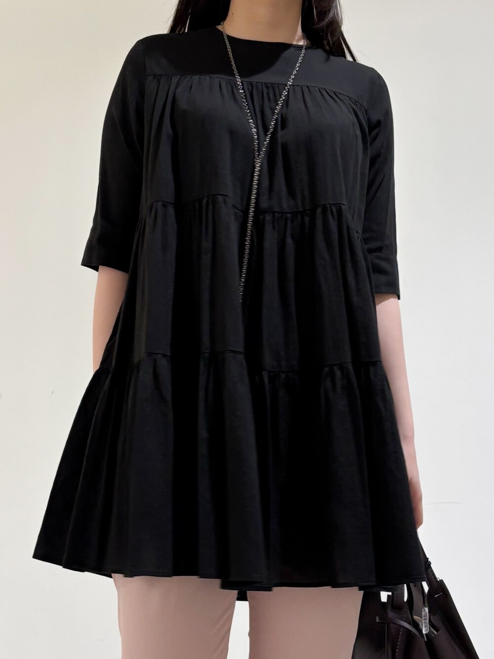 ブラック系のシャツ/ブラウス、ピンク系のスラックス、ブラック系のサンダルを着用したレディースの秋コーディネートの6枚目の写真