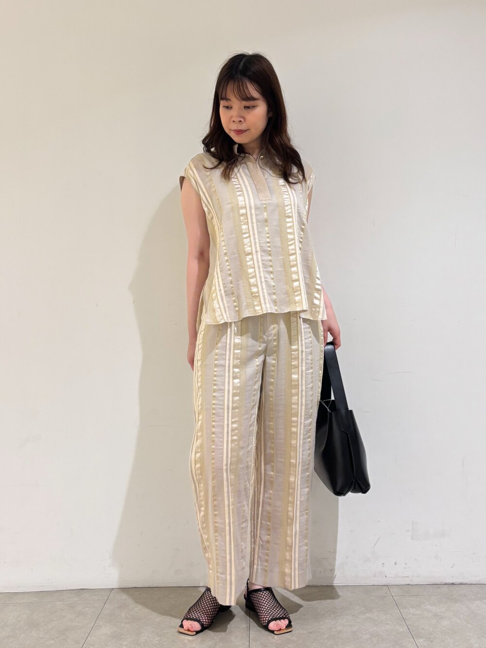 ベージュ系のシャツ/ブラウス、ベージュ系のその他パンツ、ブラック系のサンダルを着用したレディースの夏コーディネートの4枚目の写真