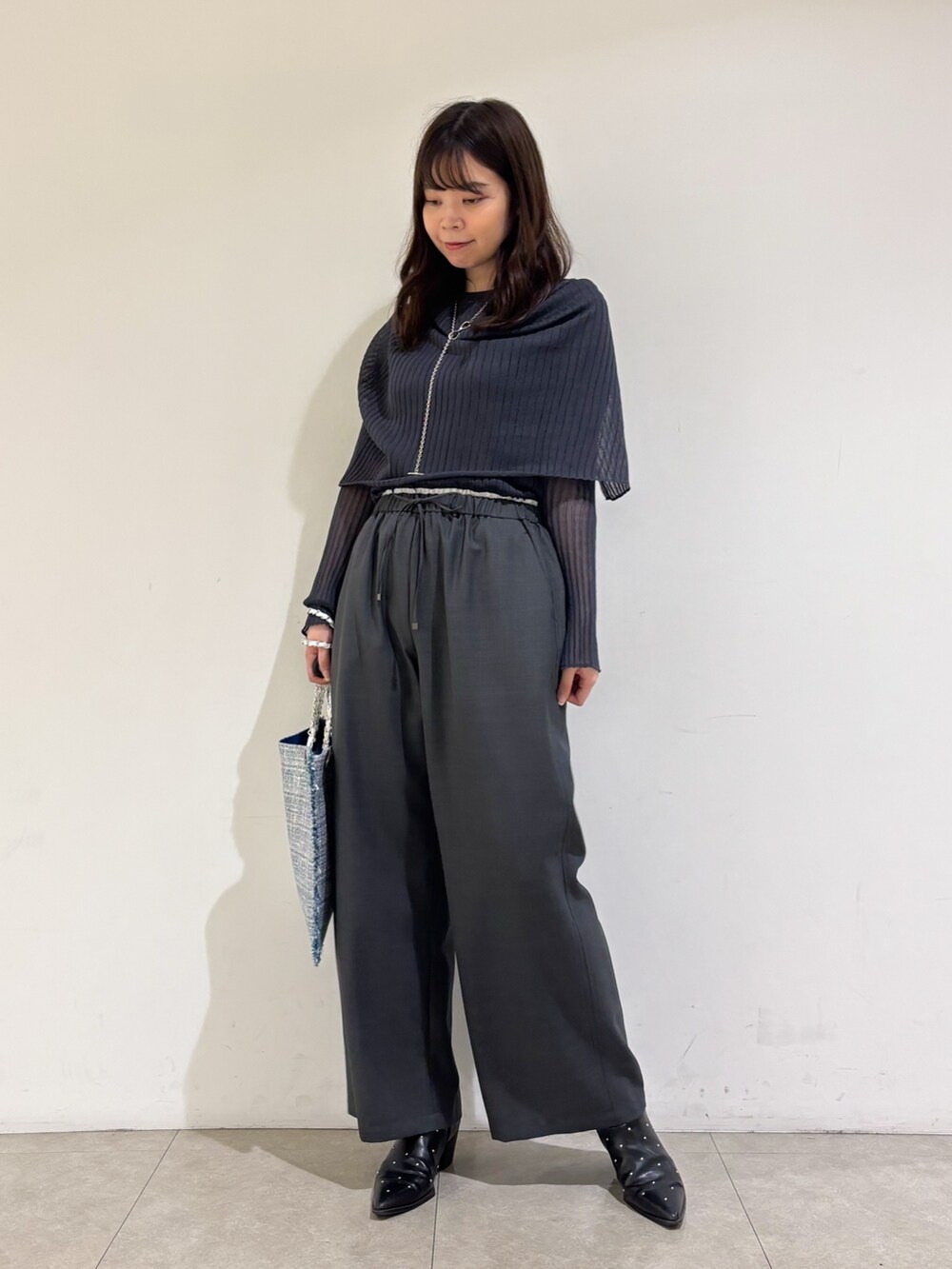 グレー系のニット/セーター、グレー系のその他パンツ、シルバー系のトートバッグを着用したレディースの秋コーディネートの2枚目の写真