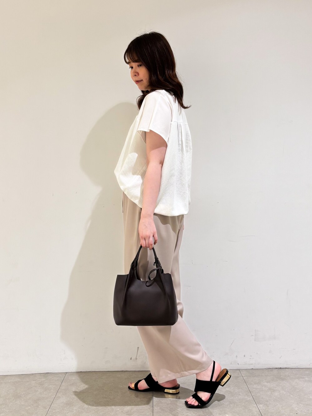 ホワイト系のTシャツ/カットソー、ベージュ系のその他パンツ、ブラック系のサンダルを着用したレディースの夏コーディネートの5枚目の写真