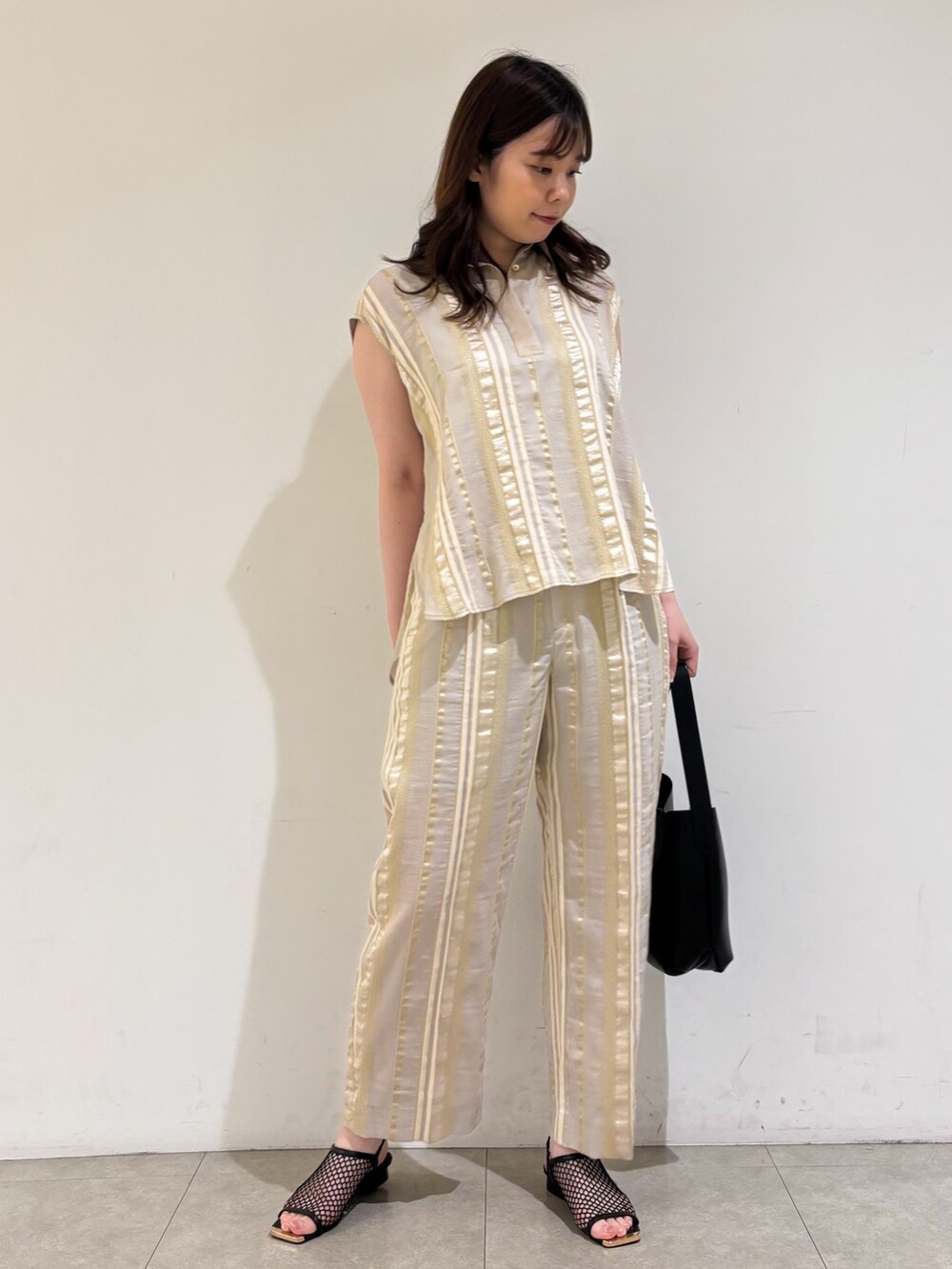 ベージュ系のシャツ/ブラウス、ベージュ系のその他パンツ、ブラック系のサンダルを着用したレディースの夏コーディネートの3枚目の写真