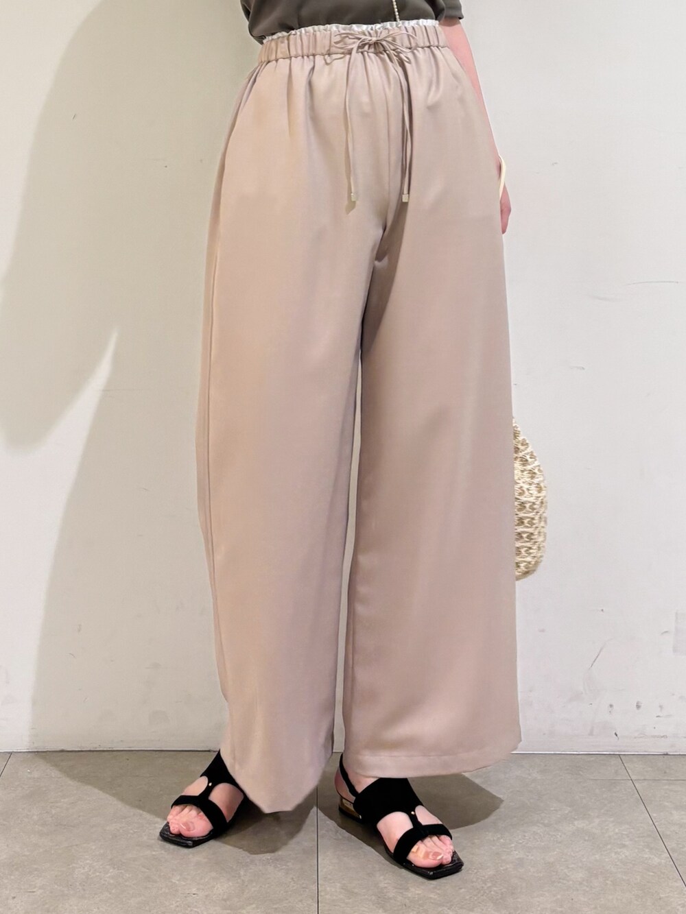 ベージュ系のその他パンツ、ホワイト系のショルダーバッグ、ブラック系のサンダルを着用したレディースの夏コーディネートの8枚目の写真