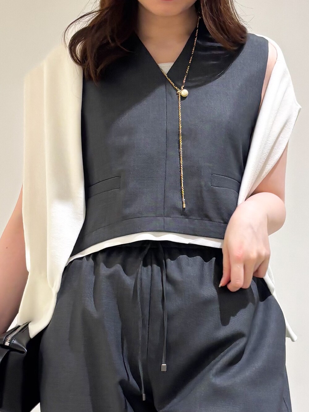 グレー系のその他パンツ、ブラック系のサンダル、グレー系のタンクトップを着用したレディースの夏コーディネートの7枚目の写真