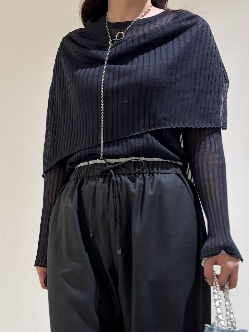 グレー系のニット/セーター、グレー系のその他パンツ、シルバー系のトートバッグを着用したレディースの秋コーディネートの6枚目の写真