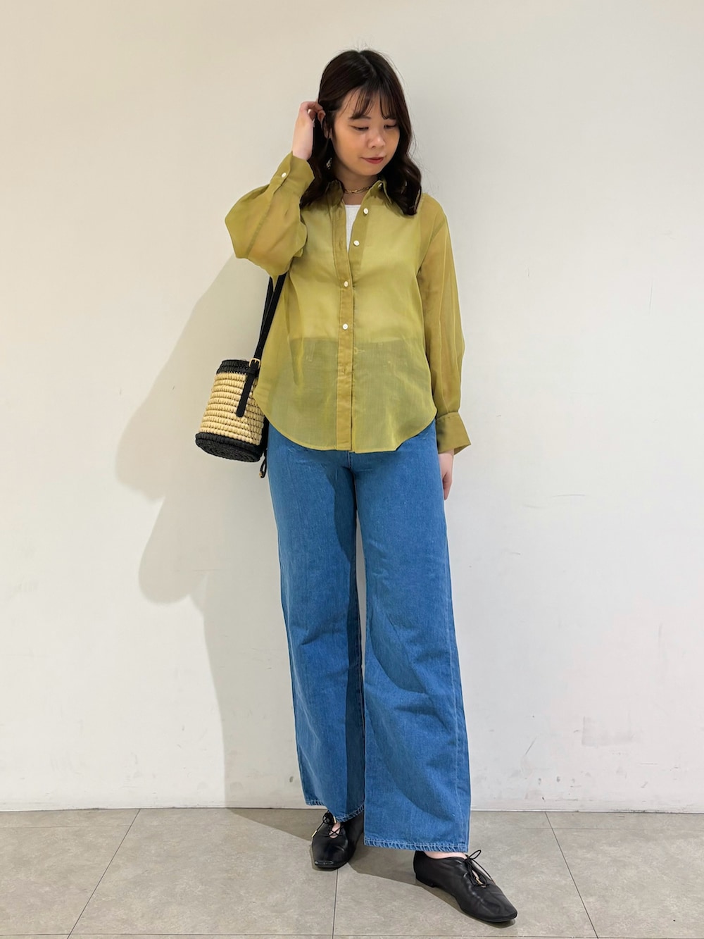 グレー系のタンクトップ、イエロー系のシャツ/ブラウス、ブルー系のデニムパンツを着用したレディースの春コーディネートの3枚目の写真