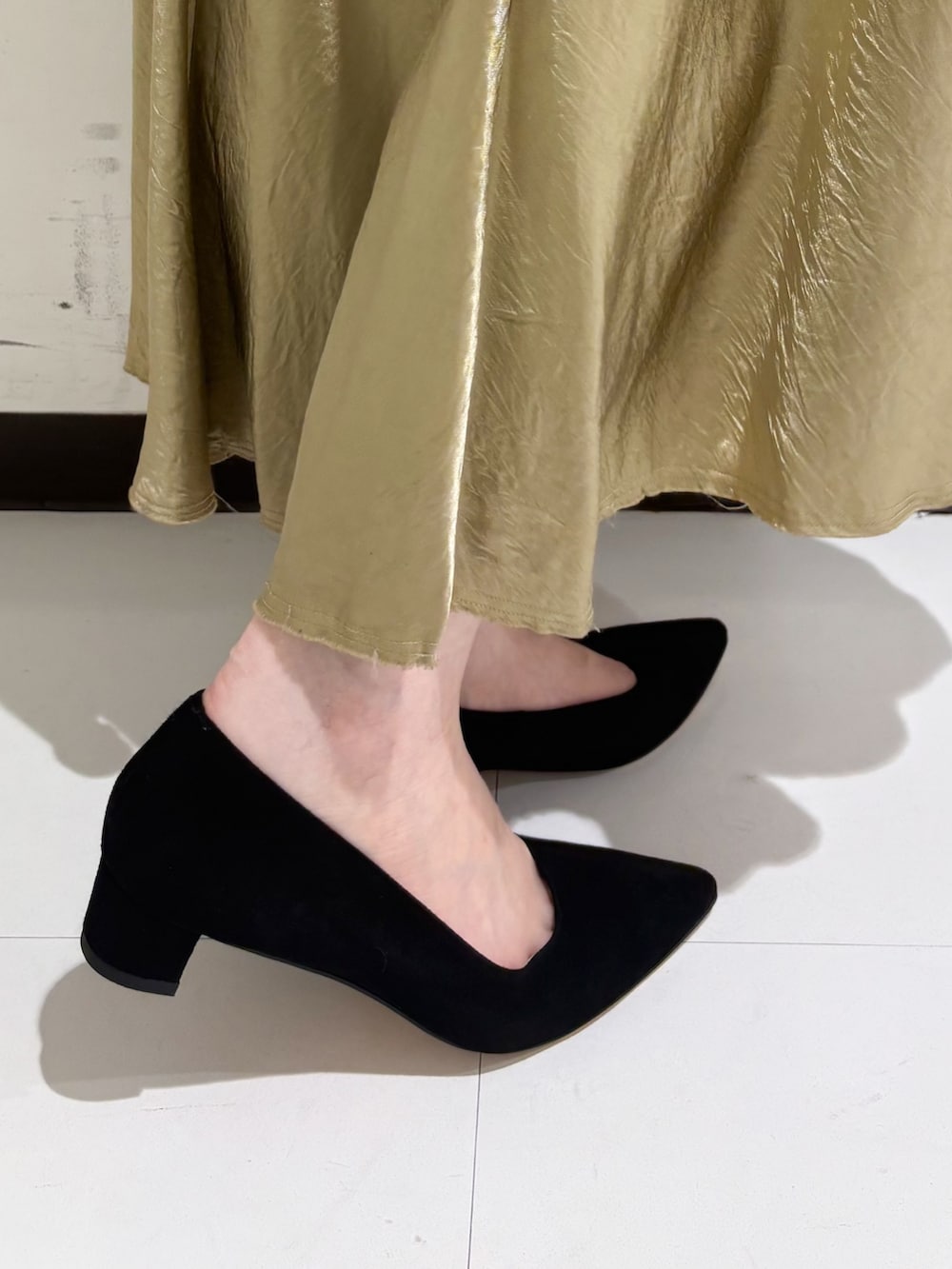 ベージュ系のショルダーバッグ、ホワイト系のトートバッグ、ブラック系のパンプスを着用したレディースの冬コーディネートの4枚目の写真