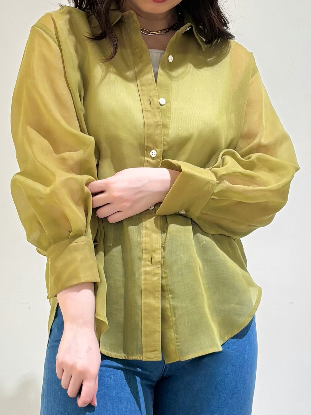 グレー系のタンクトップ、イエロー系のシャツ/ブラウス、ブルー系のデニムパンツを着用したレディースの春コーディネートの5枚目の写真