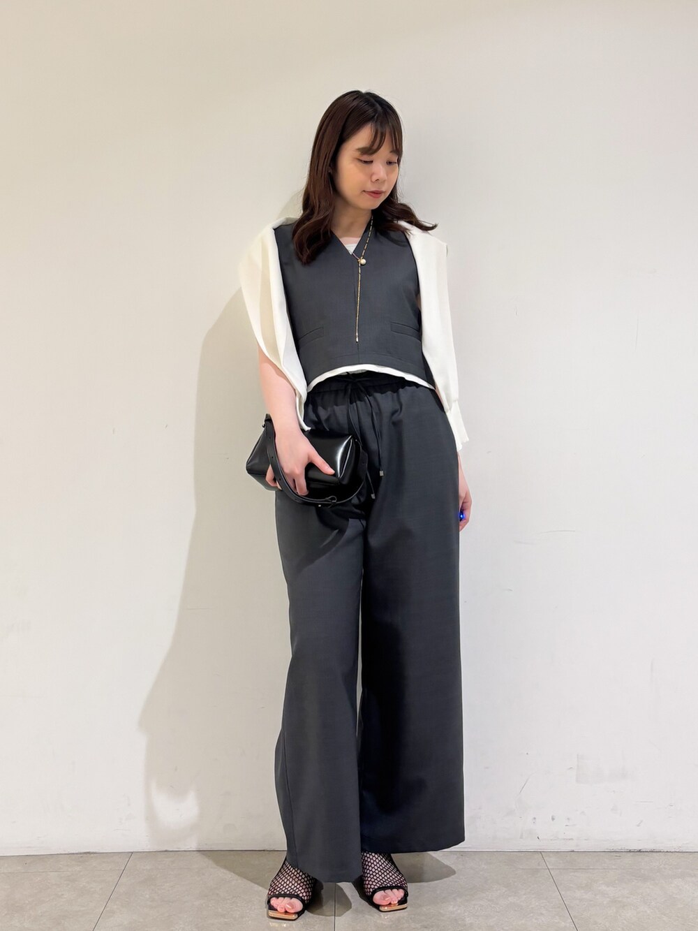 グレー系のその他パンツ、ブラック系のサンダル、グレー系のタンクトップを着用したレディースの夏コーディネートの3枚目の写真