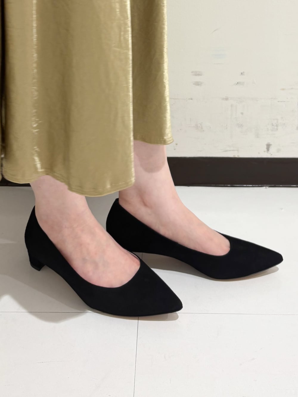 ベージュ系のショルダーバッグ、ホワイト系のトートバッグ、ブラック系のパンプスを着用したレディースの冬コーディネートの3枚目の写真