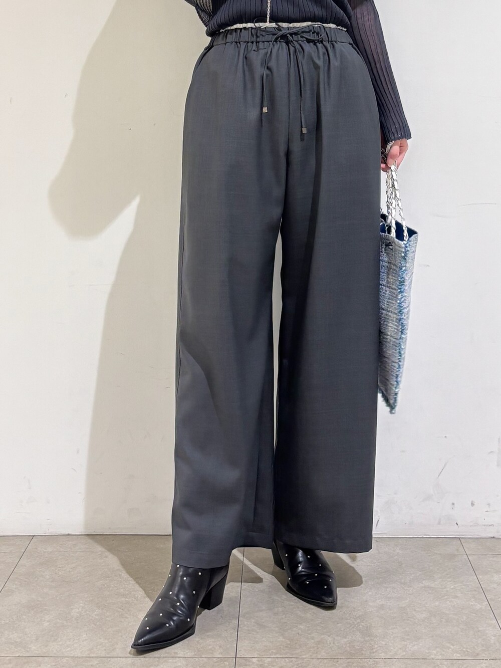 グレー系のニット/セーター、グレー系のその他パンツ、シルバー系のトートバッグを着用したレディースの秋コーディネートの9枚目の写真